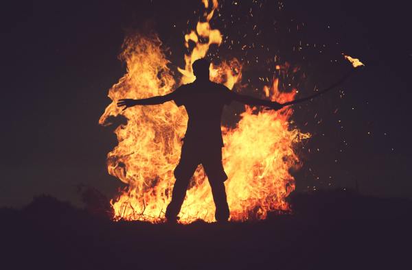 photo of a man setting a bonfire