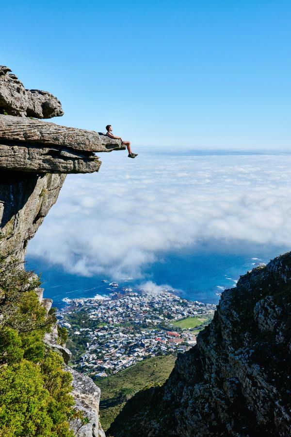 Photo of a Person Sitting on Mountain Cliff