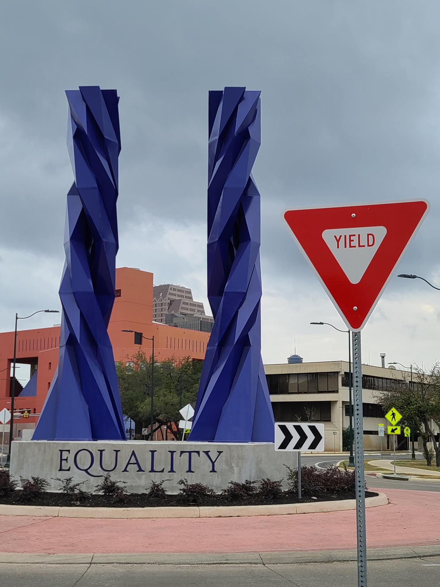 A yield sign next to an equality sculpture